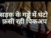 सडक के गड्ढे में घण्टों फंसी रही पिकअप वैन